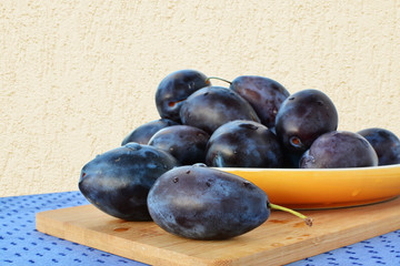 Damson plums on yellow plate