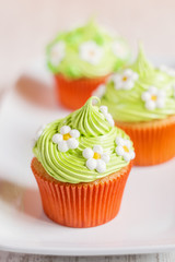 Easter cupcakes decorated with flowers on white plate