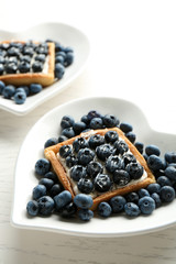 Gourmet fresh blueberry tarts on plates, close up