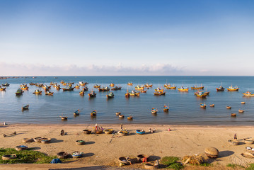 Colorful traditional fishing boats near Mui Ne, Binh Thuan, Vietnam. Early morning, fishermen float to the coast with a catch.