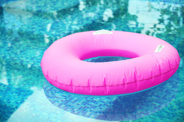 Pink pool float, pool ring in cool blue refreshing blue pool