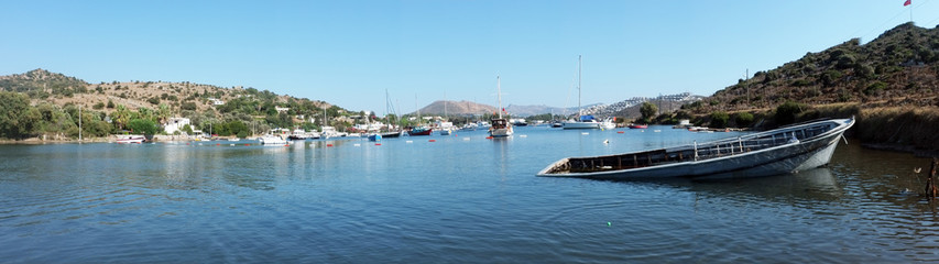 Fototapeta premium Panoramic shot of a coast with sunk boat at front