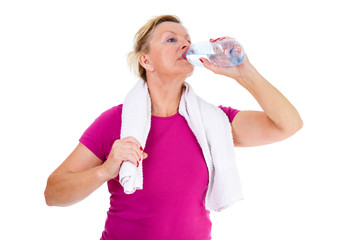 Image of old senior woman in sport outfit with white towel on her neck drinking water, isolated on...