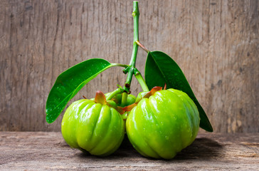 Still life with fresh garcinia cambogia on wooden background 