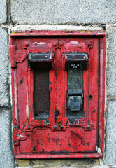Fototapeta na wymiar Long-defunct stamp dispenser on granite wall, Aberdeen, Scotland