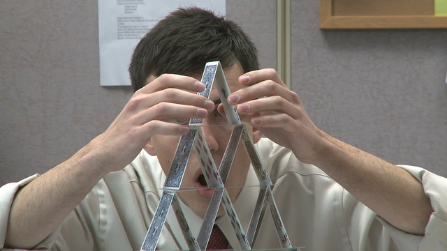 man building house of cards
