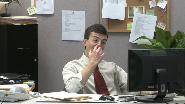 man picking his nose at work
