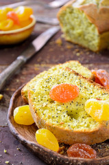 cake with kumquats and poppy seed on wooden background