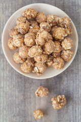 Almond and caramal popcorn on wood background