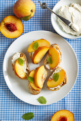 Crostini with cream cheese and fresh peaches. Top view