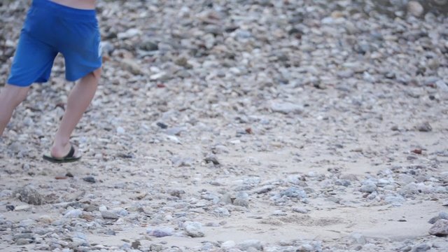 ni&ntilde;o dando toques a bal&oacute;n de playa en r&iacute;o