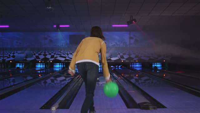 young woman bowling at a bowling alley