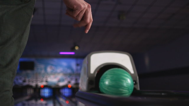 man waiting for his bowling ball to come out of the ball return