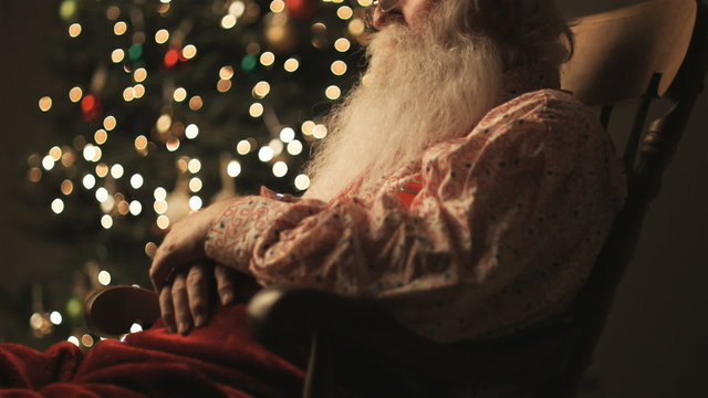 Santa Claus sitting in a rocking chair asleep
