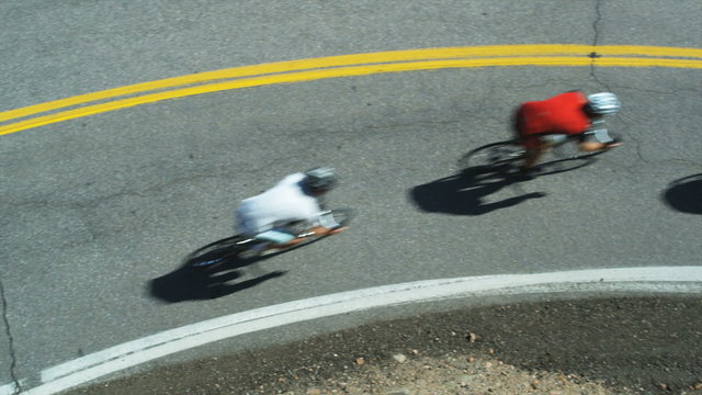 cyclists coming downhill around a bend
