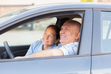 senior couple in  black car.