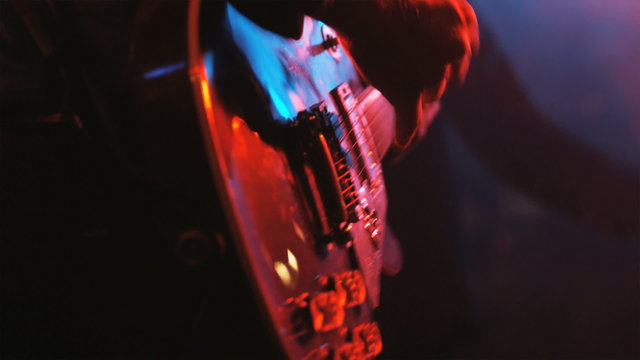 guitarist playing in a rock and roll concert with a band