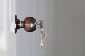 Open door with keys, key in keyhole
