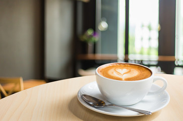 Hot art Latte Coffee in a cup on wooden table and Coffee shop bl