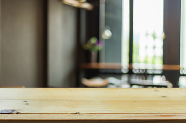 Selected focus empty brown wooden table and Coffee shop blur bac