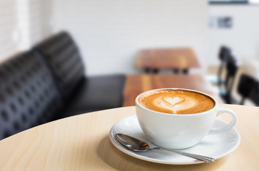 Hot art Latte Coffee in a cup on wooden table and Coffee shop bl