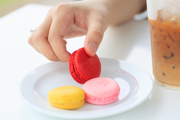 woman's hand picked a macaron