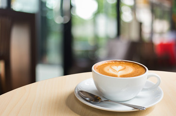 Hot art Latte Coffee in a cup on wooden table.