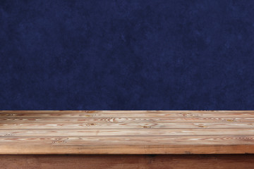 Empty wooden table against a blue wall.