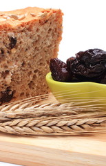 Baked wholemeal bread, dried plums and ears of wheat