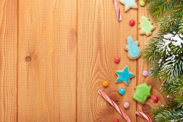 Christmas wooden background with snow fir tree, gingerbread cook