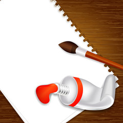 empty paper on wooden background with paint tube and brush