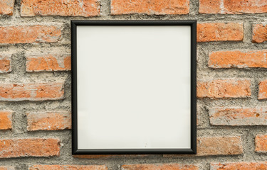blank black picture frame on old brick wall