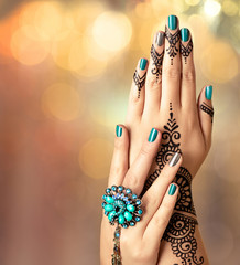 Mehndi tattoo. Woman hands with black henna tattoo