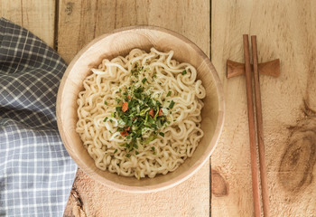 Instant noodles in bowl on wooden table