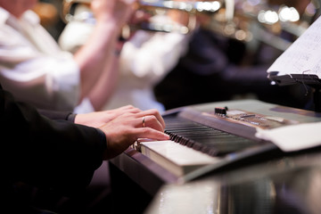 Human hand playing the synth at the concert