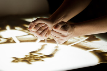  Sand animation.The girl's arms, drawing sand in dark colors