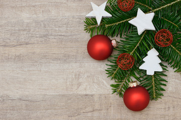 Rote Weihnachtskugeln mit Tanne auf Holz