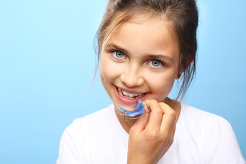 Proste zdrowe zęby dziecka. Dziewczynka z kolorowym aparatem ortodontycznym 