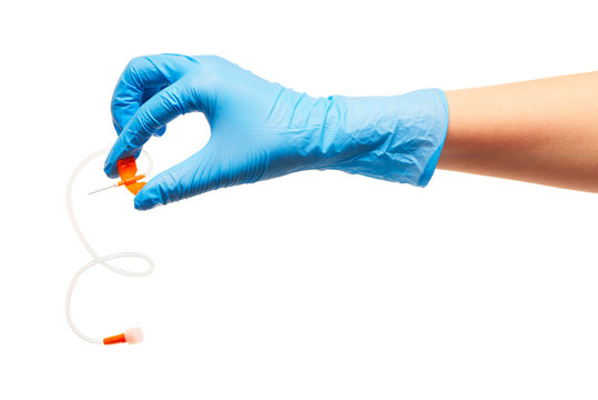Close up of female doctor's hand in blue sterilized surgical glove with orange plastic catheter against white background