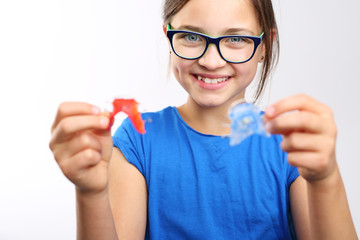 Dziewczynka z kolorowym aparatem ortodontycznym  - obrazy, fototapety, plakaty