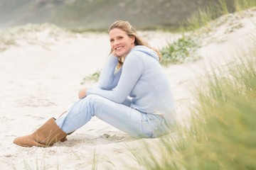 Smiling woman sitting on the sand