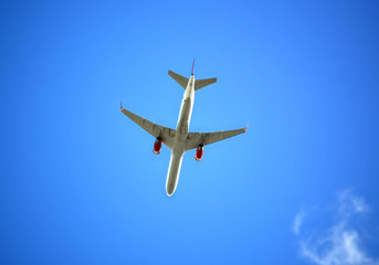 Летящий пассажирский самолет на фоне синего неба