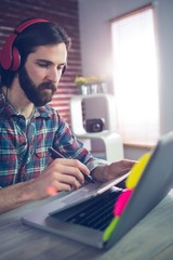 Businessman with headphones using graphic tablet