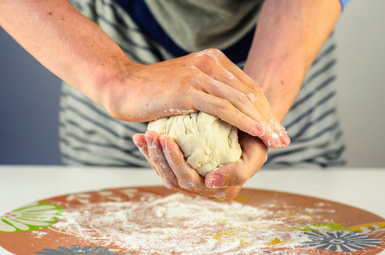 Man hands making dough for dumplings with meat