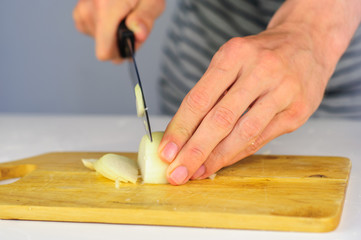 Obraz na płótnie Canvas Man hands cutting onion