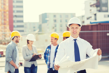group of builders with tablet pc and blueprint