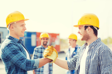 group of smiling builders in hardhats outdoors