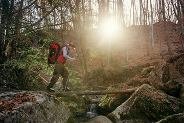 Adventure man hiking in woods with backpack, outdoor lifestyle