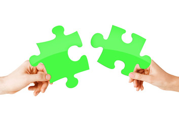 close up of couple hands with green puzzle pieces