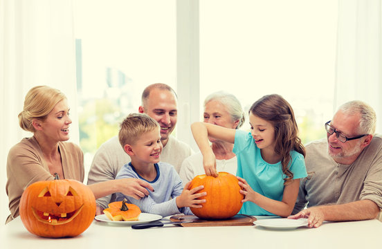 Happy Family Sitting With Pumpkins At Home